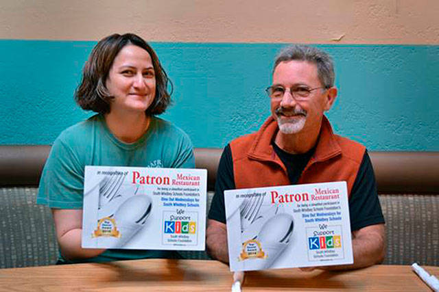 Patron Mexican restaurants manager Anna Campante and School Foundation president Chris Gibson hold some of the Dine Out for South Whidbey Schools recognition plaques the restaurant has received. Photo provided.