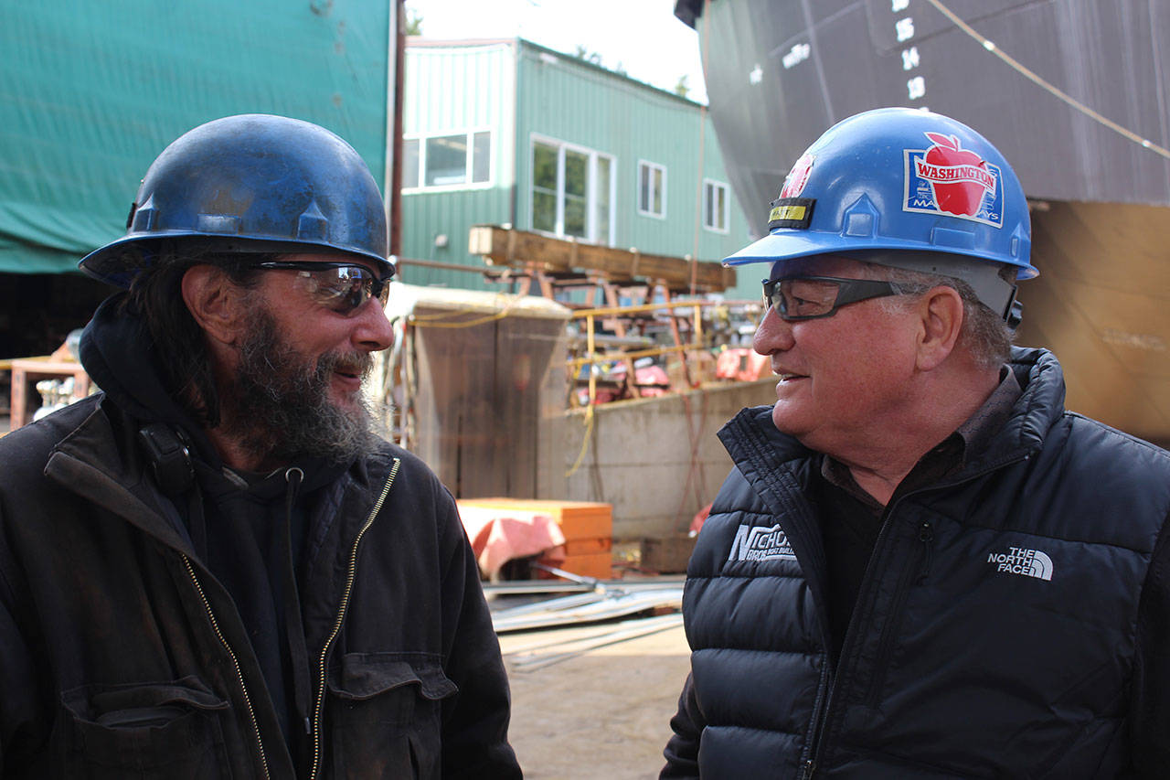 Lead ship fitter Greg Von Pressentin, left, chats with Matt Nichols Thursday as final plans are made to launch an articulated tug boat. “Matt is family,” said Von Pressentin, who’s worked at the company since 1990. “He’s been a boss, a father, a brother and a shoulder to cry on.” Photo by Patricia Guthrie/Whidbey News Group
