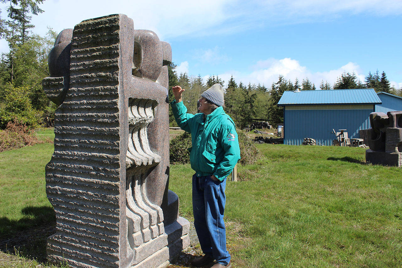 Hank Nelson stands near one of his 8-foot granite sculptures, one of hundreds within Cloudstone Sculpture Park.