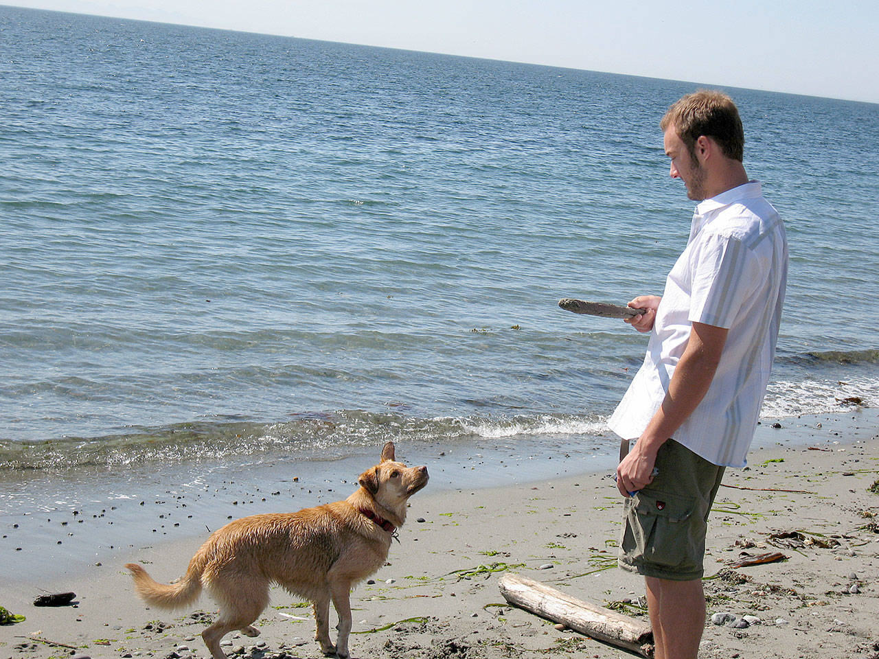 Judith Gorman submitted photo                                Orrin McClellan plays with his dog Koda-Bear at Useless Bay in 2009.