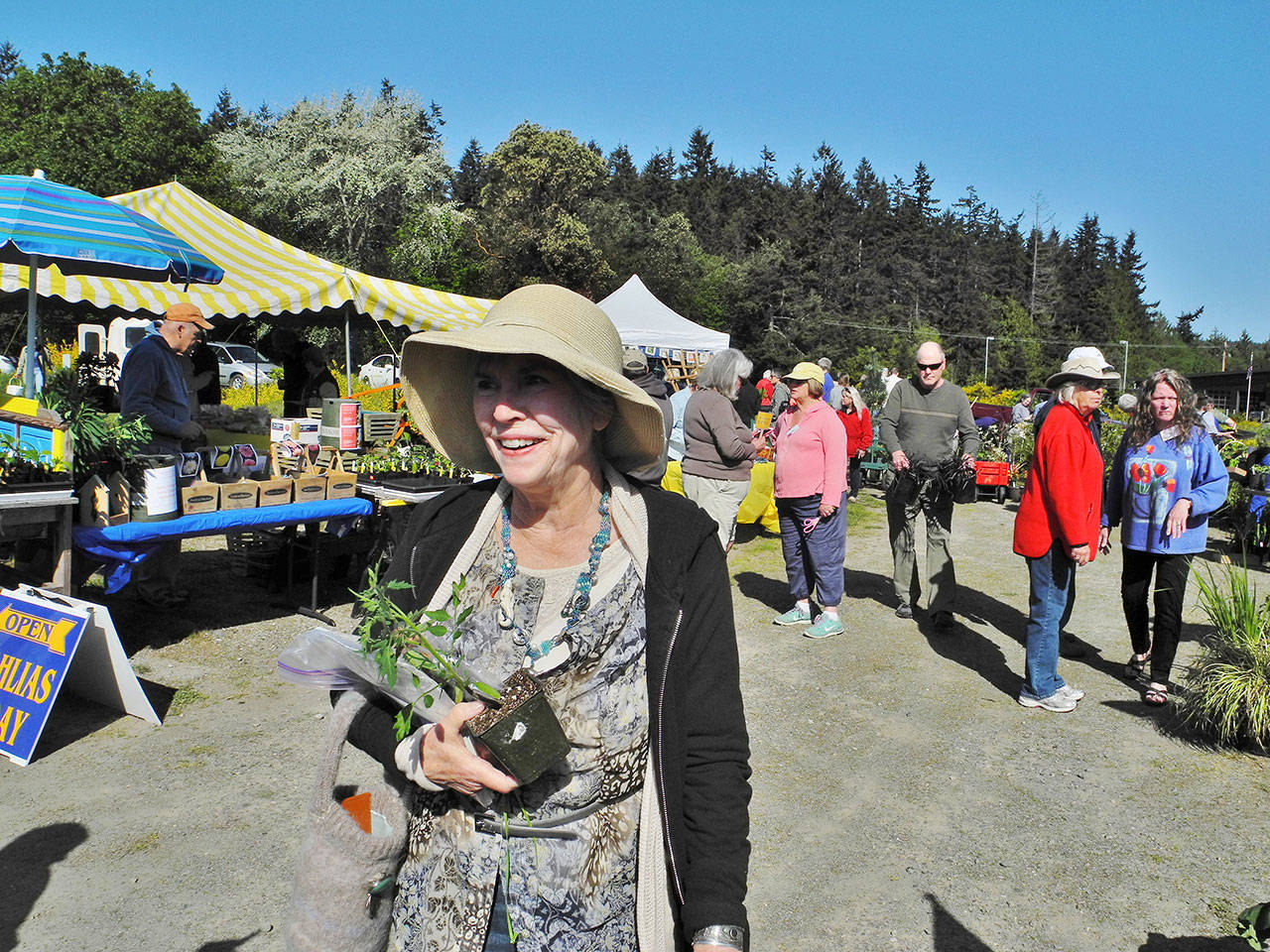 A happy customer leaves the 2017 plant sale of South Whidbey Garden Club. On April 28, the clubs annual sale will be indoors for the first time at Bayview Community Hall. Photo provided