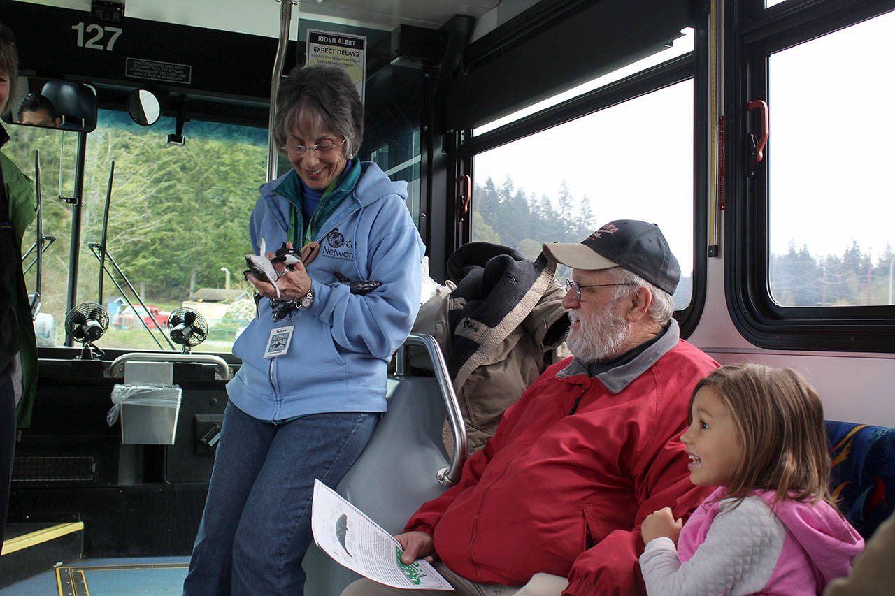 Kylie Beard, 5, tells her grandfather, Tom Beard, what she knows about orcas as Langley Whale Center guide Bonnie Gretz holds a tiny whale. Photo by Patricia Guthrie/Whidbey News-Group