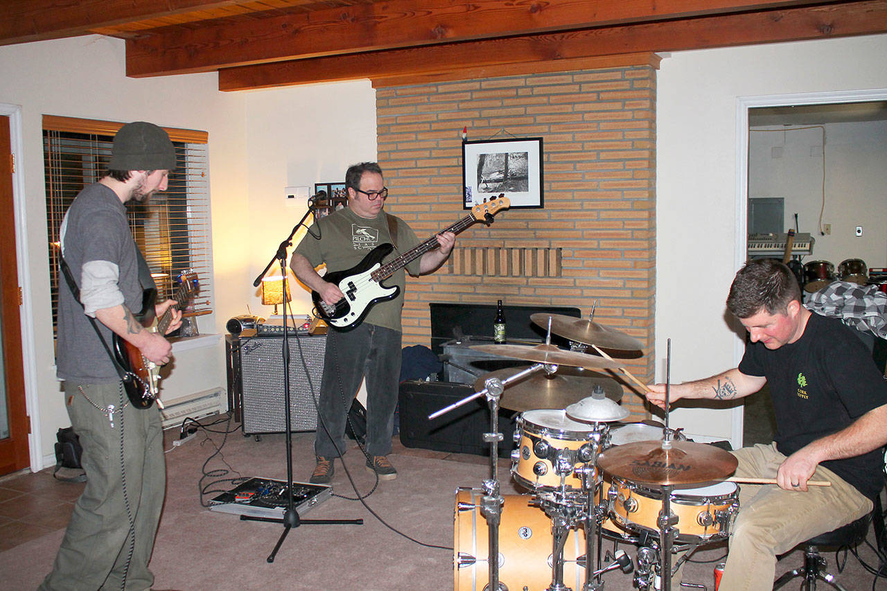 Photo by Joseph Savidge for the South Whidbey Record                                Lead singer and bass guitarist Donald Singleton (center), drummer Randy Wolfe and guitarist Max LeMay of the band Mylo practice for upcoming performances.