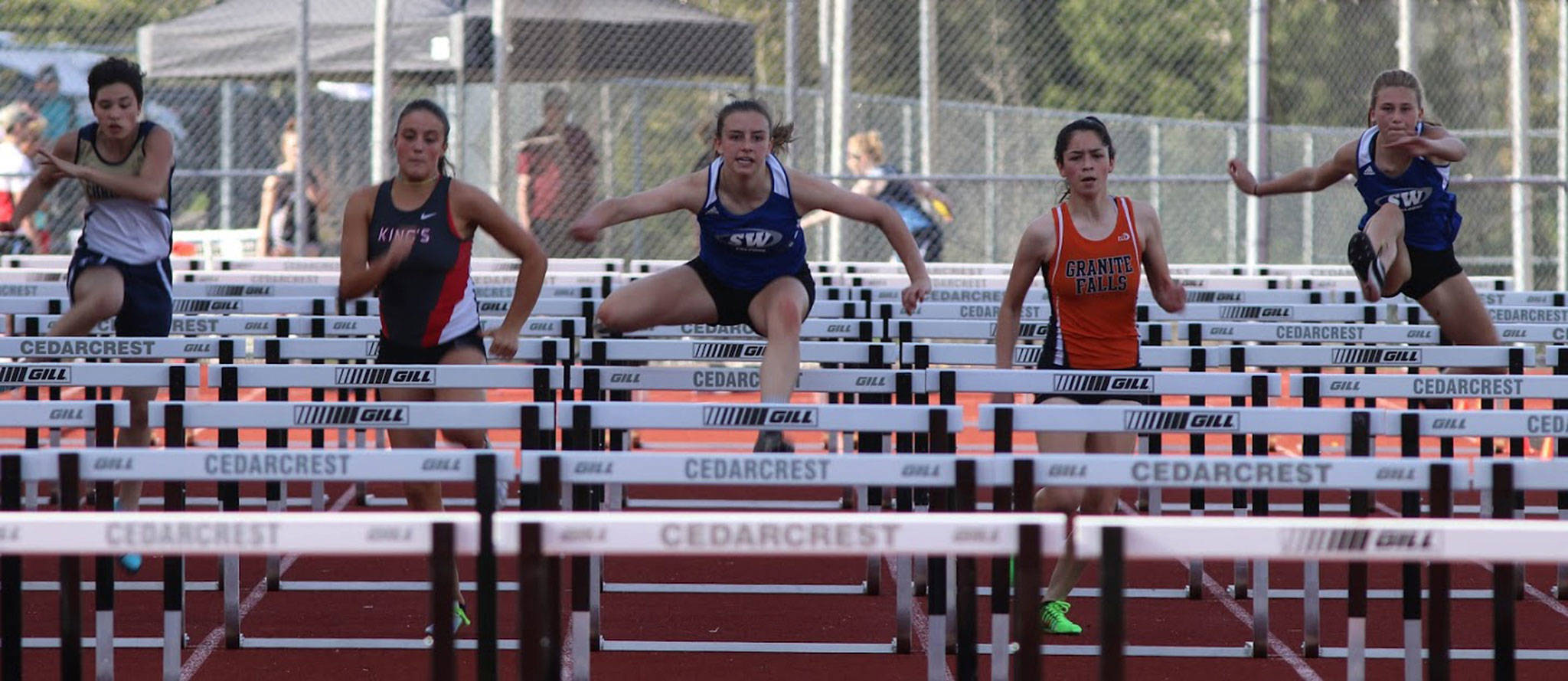 South Whidbey’s Sophia Nielsen, center, sails to first place in the 100 hurdles at the league meet Thursday. (Photo by Matt Simms)