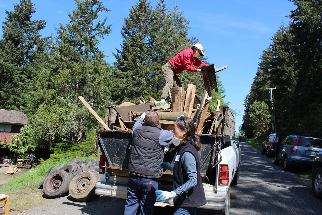 Volunteers working with South Whidbey Hearts & Hammers Saturday helped a longtime Freeland homeowner get rid of decades of yard debris and possessions ruined by water damage and rodents. Photo by Patricia Guthrie/Whidbey News Group