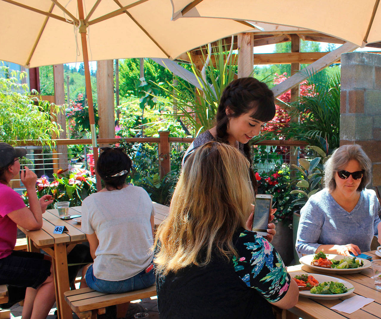 After being closed two months for renovation, Flower House Cafe in Bayview reopened over the weekend. Server Mary Petosaprovides lunch to two diners Monday. Photo by Patricia Guthrie/Whidbey News Group