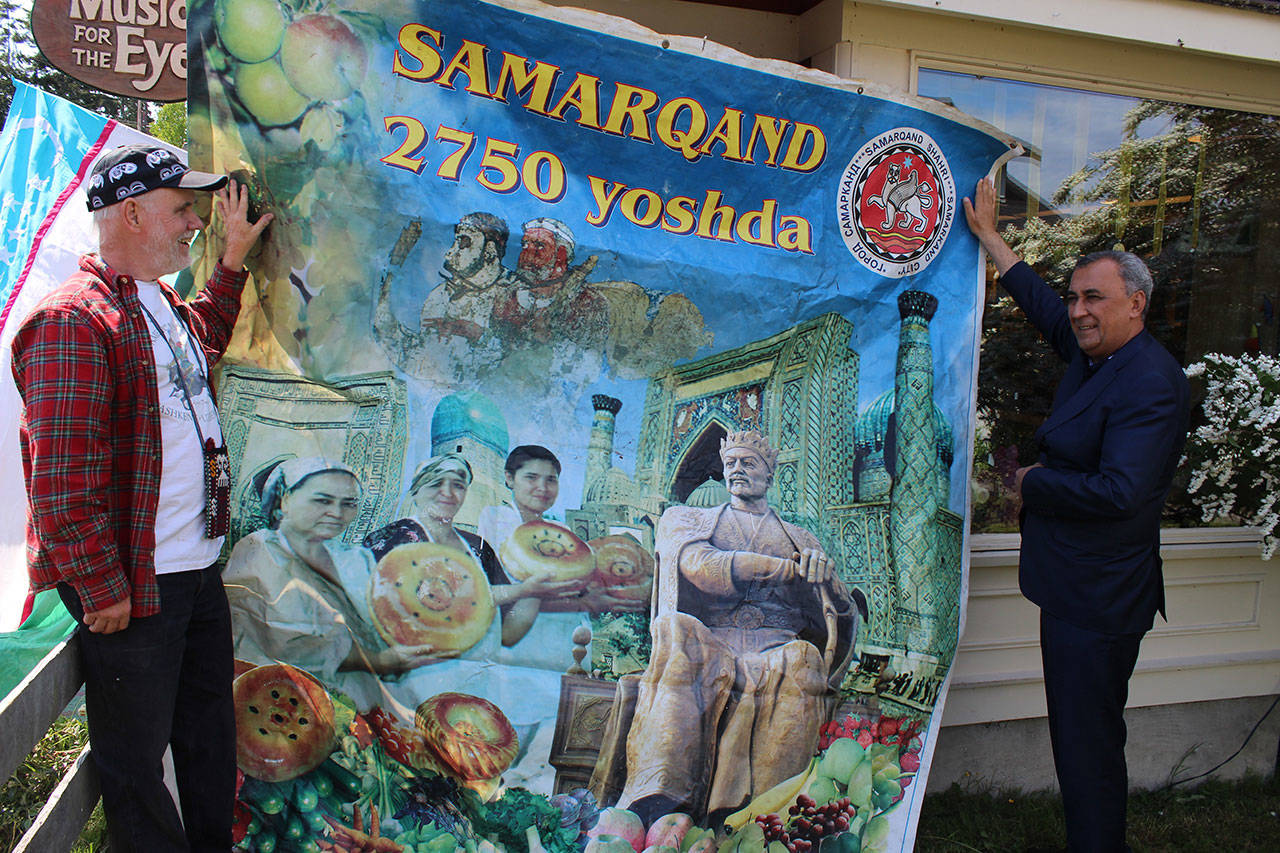 Music for the Eyes store owner Fred Lundahl (left) stands with Furqat Rakhimov, mayor of Samarkand, a city in Uzebekistan situated at the crossroads of the Silk Road. The banner uses the Uzbek spelling of the city and advertises its 2,750 year-old history.