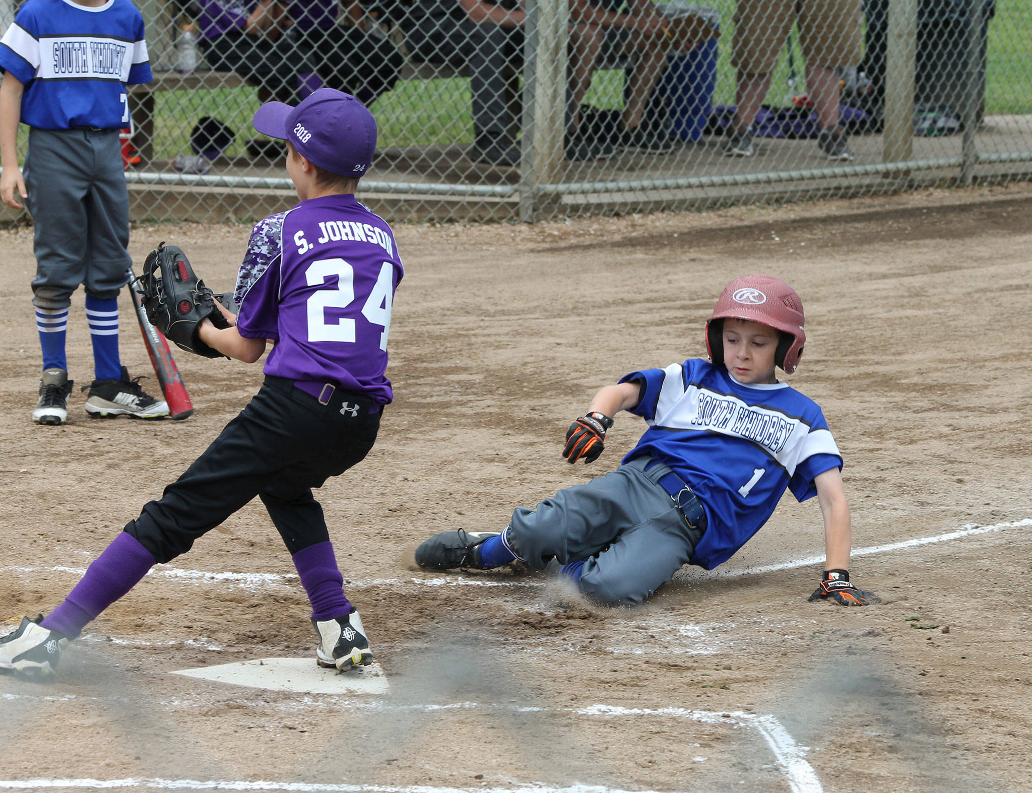 Alexander Zarifis scores a run on a wild pitch as Anacortes Sam Johnson covers the plate.(Photo by Jim Waller/South Whidbey Record)