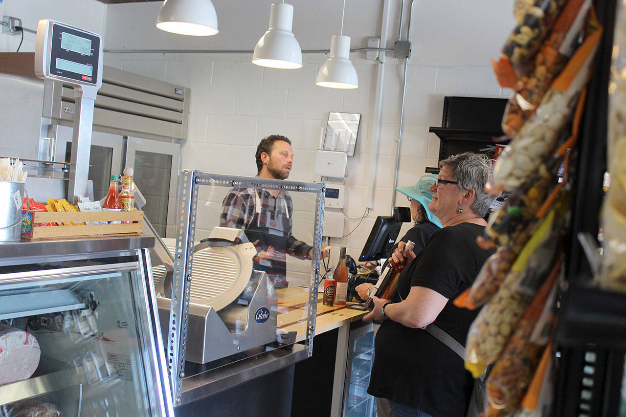 Alex Pulichino waits on costumers at the new Greenbank Pantry and Deli that sells groceries, fresh items, wine, beer and freshly-made salads and sandwiches. Hours are 8 a.m.to 6:30 p.m. every day; closed Sunday. Photo by Patricia Guthrie/Whidbey News Group