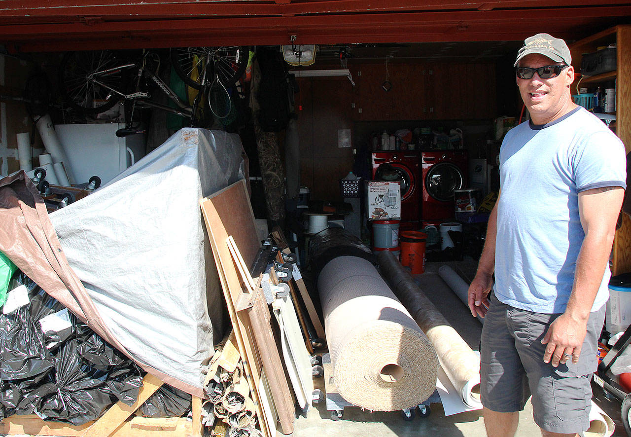 Dave Madeiros stands in front of his garage, where he keeps the materials he uses for his flooring business that he has owned and operated since 2001. He still lives in the first home he bought in Oak Harbor after being homeless for a two years. Photo by Emily Gilbert/Whidbey News-Times                                Photo by Emily Gilbert/Whidbey News-Times                                Dave Madeiros stands in front of his garage, where he stores materials he uses for his flooring business that he has owned and operated since 2001.