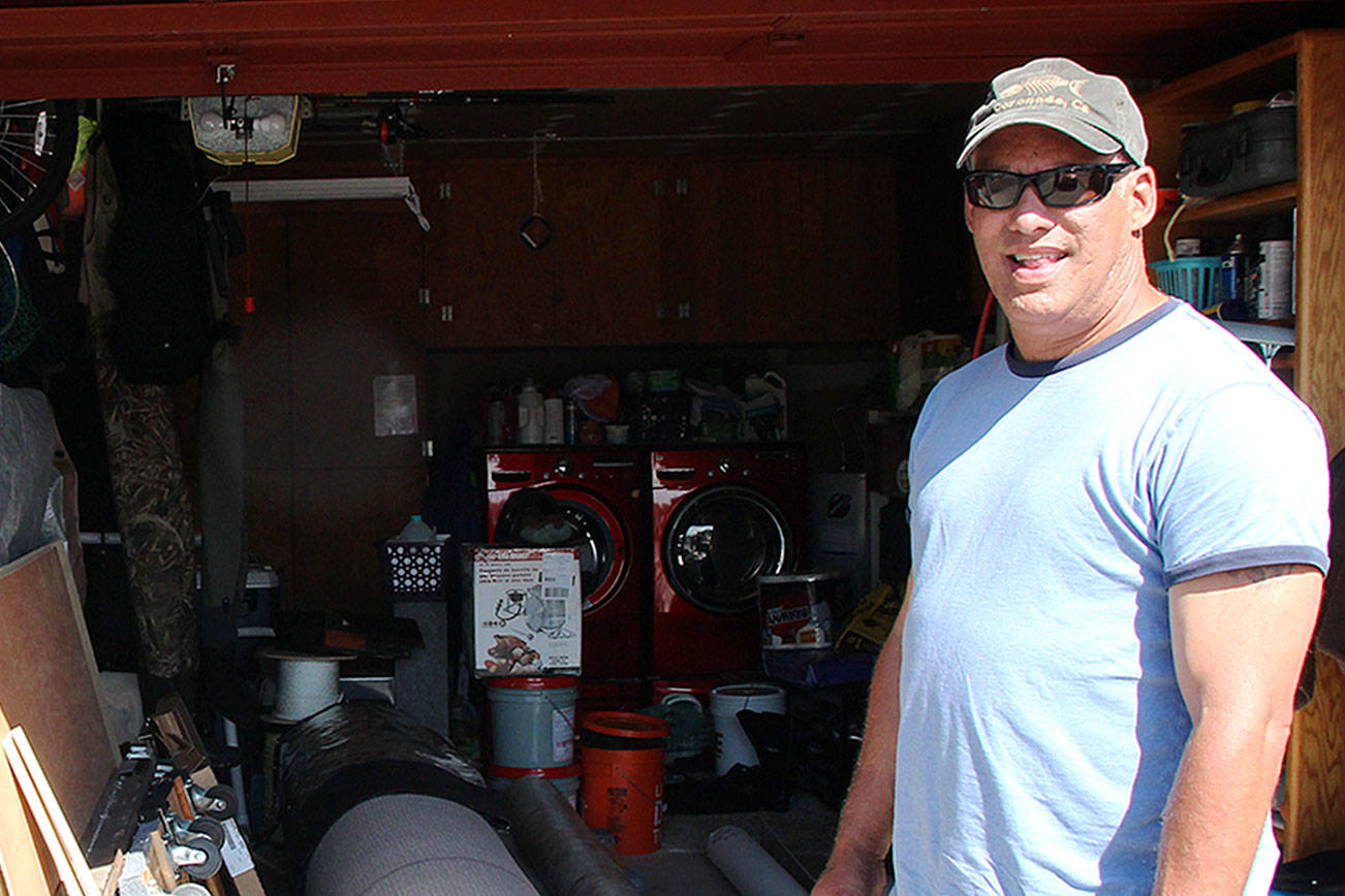 Photo by Emily Gilbert/Whidbey News-Times                                Dave Madeiros stands in front of his garage, where he stores materials he uses for his flooring business that he has owned and operated since 2001.