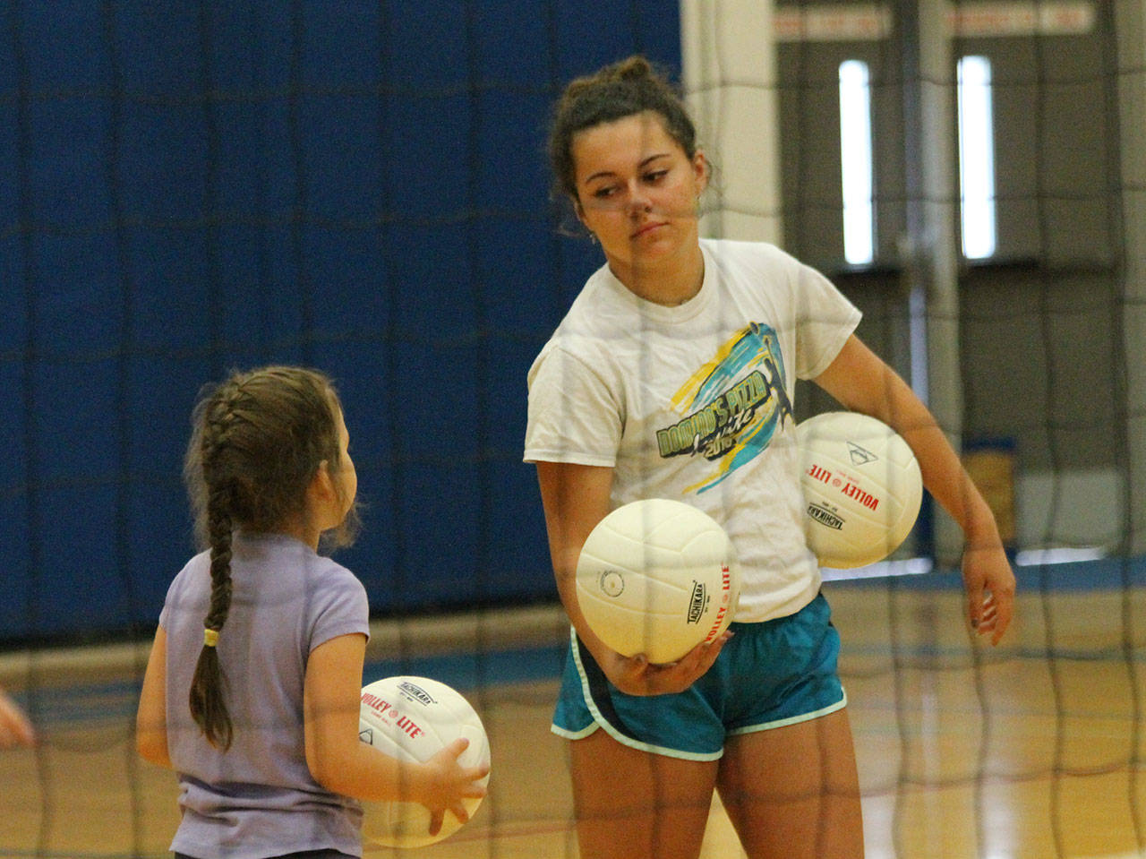 Eleida Bonnell, left, asks assistant coach Angelina Wilson a question at volleyball camp this week.(Photo by Jim Waller/South Whidbey Record)