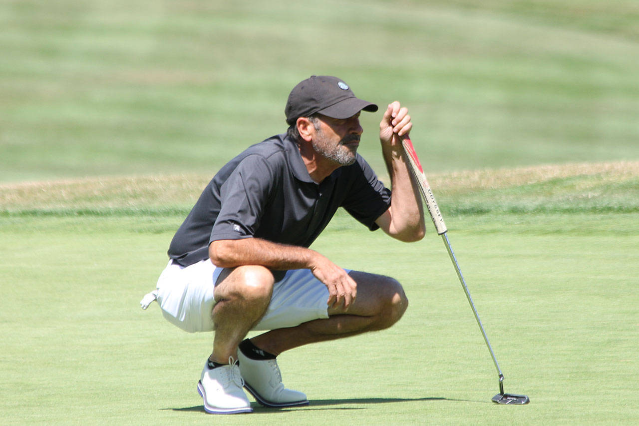 Winner Buz McKinley lines up a putt during the South Whidbey Invitational Friday. (Photo by Jim Waller/South Whidbey Record)