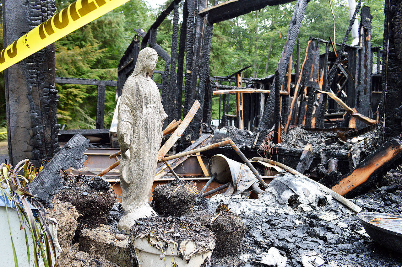 A Virgin Mary statue stands, mostly undamaged, among the remnants of a house that burned down Thursday night in Freeland. The cause is being investigated and no one was injured. Photo by Laura Guido/Whidbey News Group