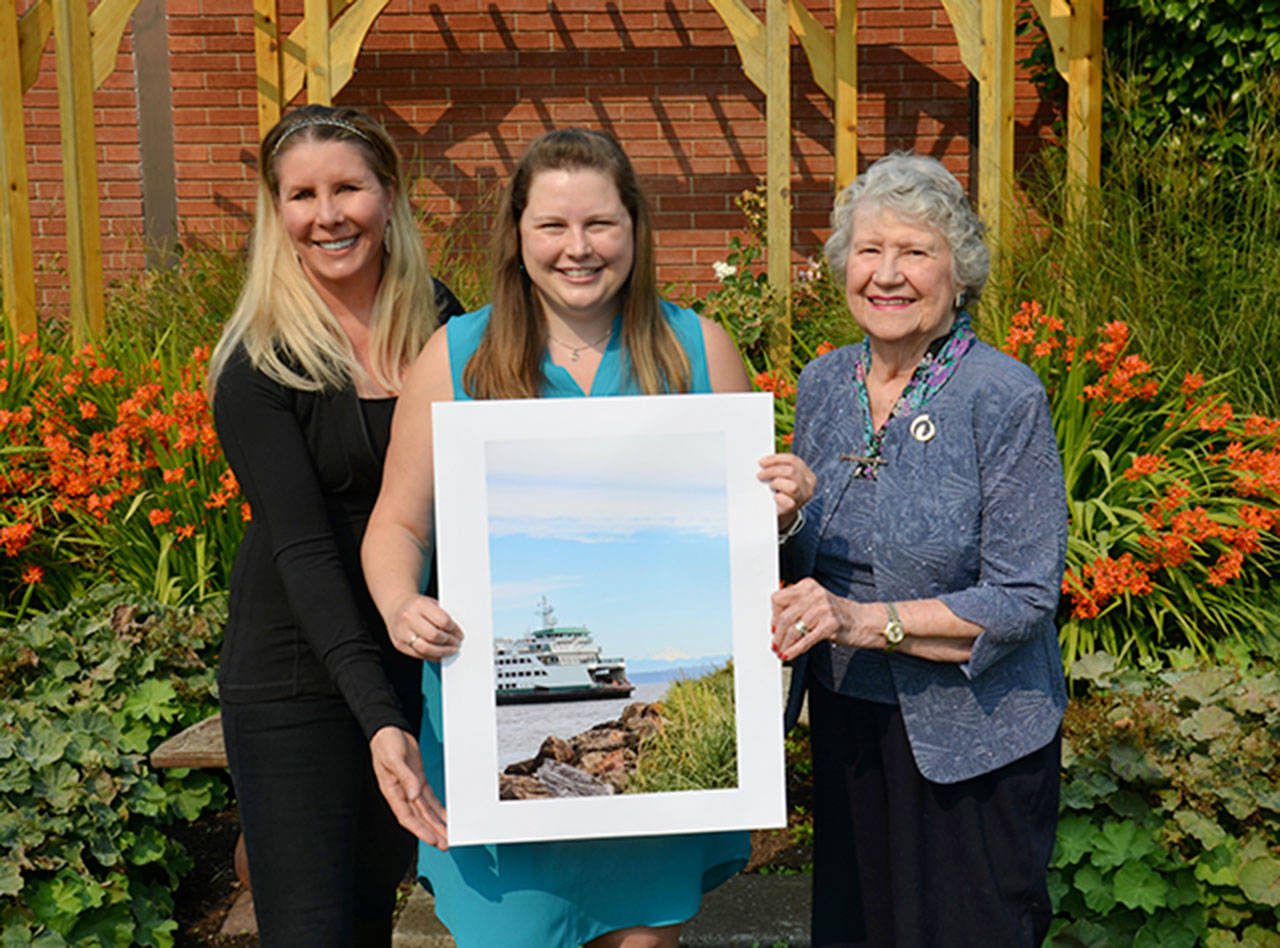 Whidbey Telecom Chairperson Marion F. Henny (right), Erin Meehan with her photograph, “Island Bound” and Co-CEO Julia Henny pose for a photo.