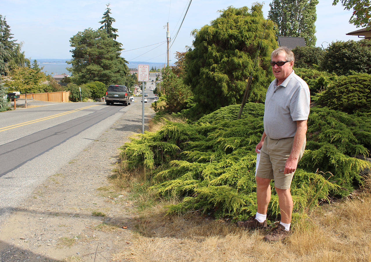 The paving project on Second Street in Langley will extend asphalt to private property lines. Public Works Director Stan Berryman stands where some vegetation will have to be removed. (Photo by Patricia Guthrie/Whidbey News Group)