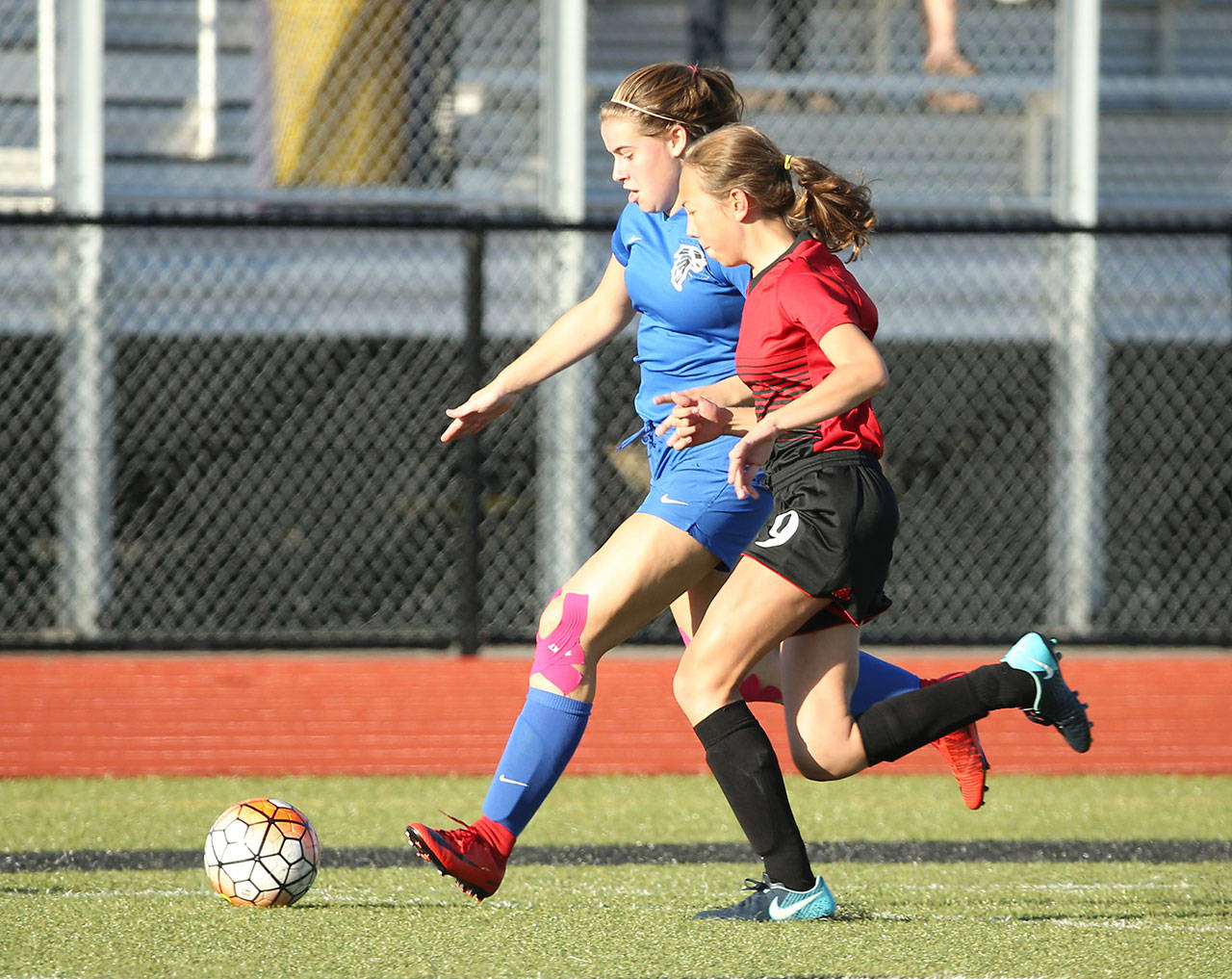 Samantha Ollis races Coupeville’s Mary Milnes to the ball.(Photo by John Fisken)