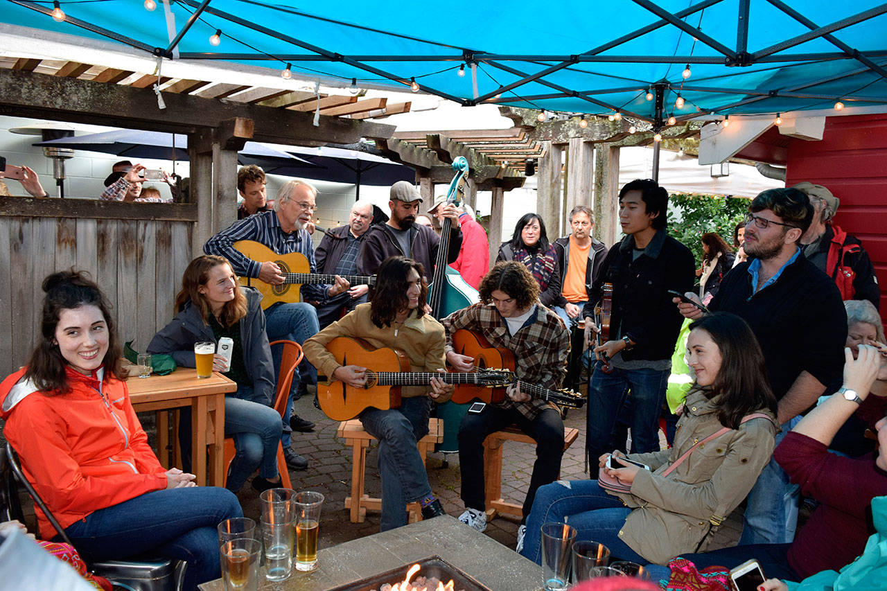 It began with two guitar players and one singer late Saturday afternoon in Langley during Djangofest Northwest 2018. An hour later, ten musicians were jamming on the patio of Double Bluff Brewey for soon-to-be bride, Jill Denkmann, far left, and her bachelorette party. Michael Doces, far right, is a singer who often visits his family’s Freeland property.                                (Photo by Patricia Guthrie/Whidbey News Group)