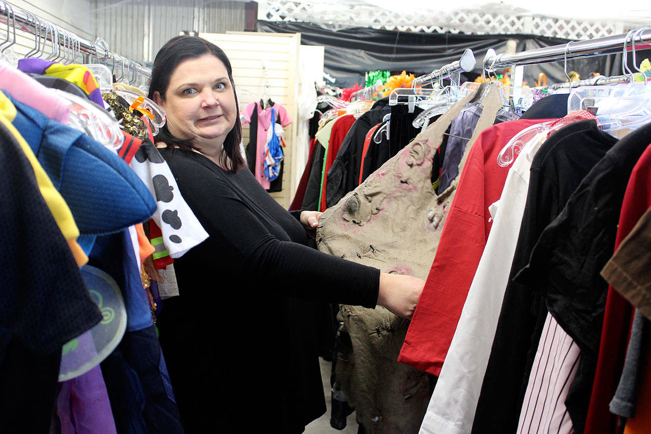 Island Thrift employee Dena Moreno reacts to a creepy costume for sale at the store’s Halloween Headquarters. Hundreds of inexpensive Halloween decorations and disguises are for sale. (Photo by Patricia Guthrie/Whidbey News Group)