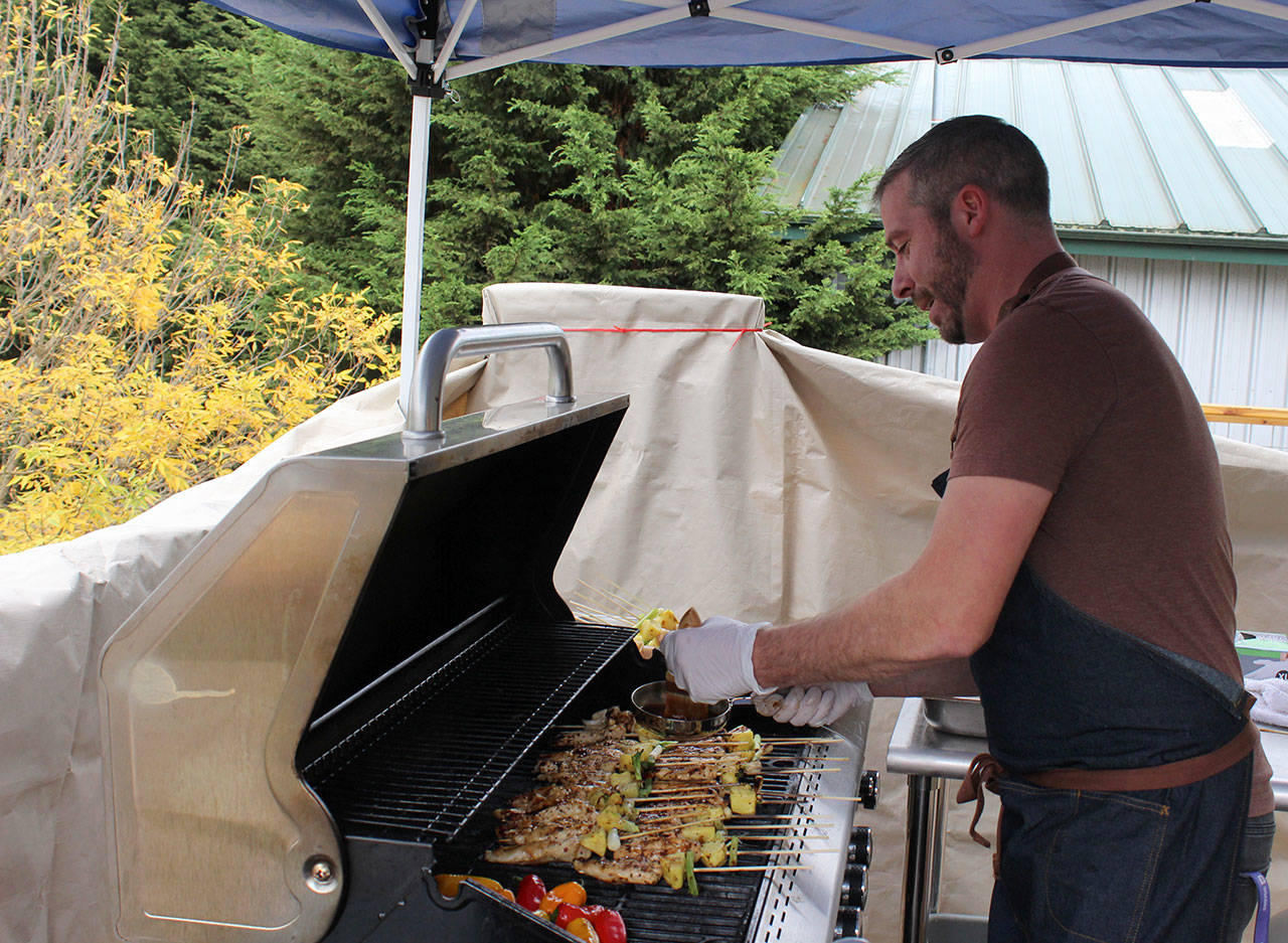 Chef Wayne Carter tends to skewers of chicken, peppers and pineapple on the patio grill. He’s using the temporary outside grilling area until the interior stove is completely installed.