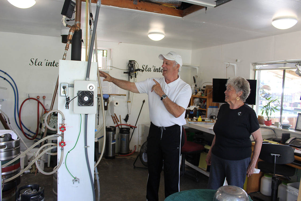 Harry Sloan and Kathy Parks give a tour of their small distillery assembled in a converted boathouse overlooking Cultus Bay. (Photo by Patricia Guthrie/Whidbey News Group)