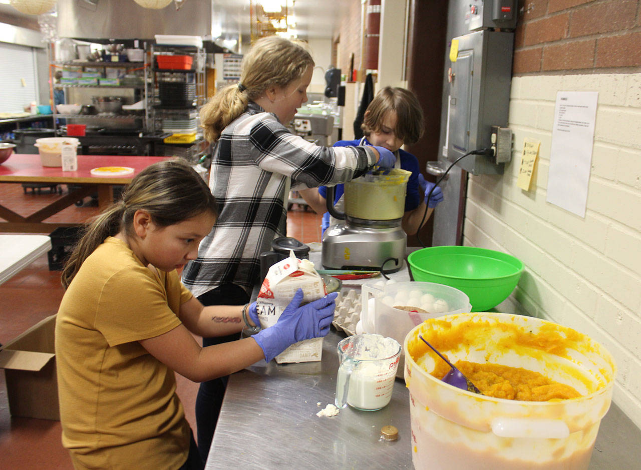 Olivia Livingstone, left, Kjersti Ringsrud, center, and Emery Fisher carefully measure ingredients for their pies. (Photo by Patricia Guthrie/Whidbey News Group)