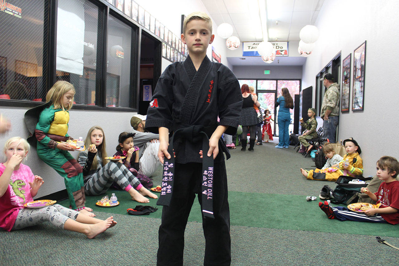 Weston Dill, 9, shows his taekwondo black belt. It’s embroidered in pink with his name and rank in English and Korean. (Photo by Patricia Guthrie/Whidbey News Group)