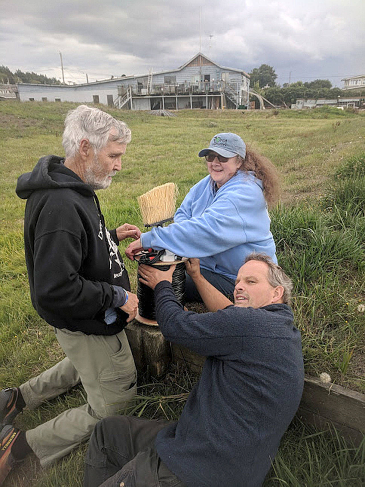 Howard Garrett, left, Susan Berta and Florian Graner roll out the long cable needed to install a hydrophone to listen to marine life. The research sound equipment is located at Bush Point in the sound path of killer whales and other marine mammals. (Photo provided)
