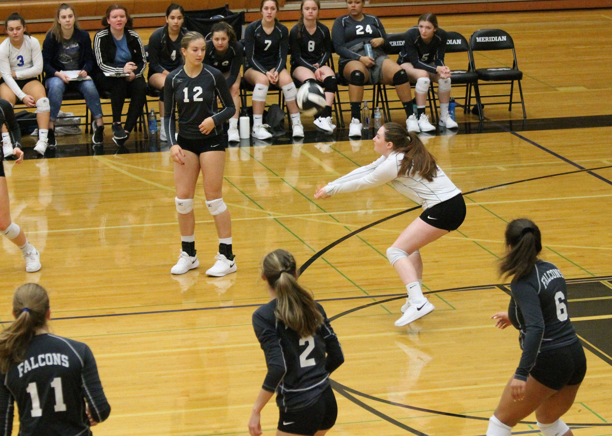 Kayla Knauer (white jersey) sets up to pass the ball as Emma Hodson (11), Emma Leggett (12), Alyssa Ludtke (2) and Maya Tschetter look on.(Photo by Jim Waller/South Whidbey Record)
