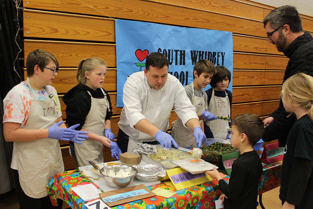 Culinary educator David Phillips serves some of the 75 pounds of potatoes cooked by the student Farm Team for the annual Harvest Feast at South Whidbey Elementary School.                                 (Photo by Patricia Guthrie/Whidbey News Group)