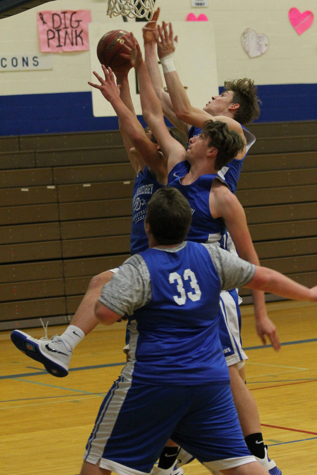 Kole Nelson (center) and Carson Wrightson (taped wrist) battle a teammate for a rebound as Lewis Mattson looks on.(Photo by Jim Waller/South Whidbey Record)