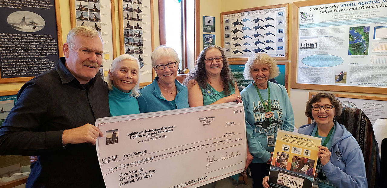 Lighthouse Environmental Programs staff present a $3,000 donation to Orca Network volunteers.                                Left to right: Lighthouse president Rick Blank and staff Ellen Dickey, Wendy Visconty and Orca Network founder Susan Berta and volunteers Shari Devlin and Wendy Sines. (Photo provided)