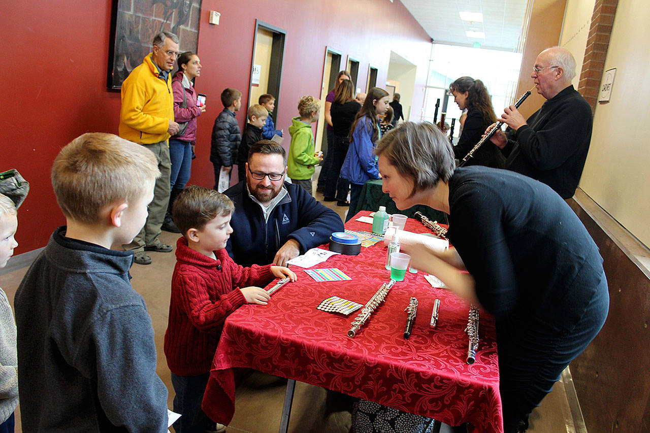 During the Instrument Petting Zoo, members of the Saratoga Orchestra show how their instruments work and encourage children to take a toot, strum or drum. (Photo by Patricia Guthrie/Whidbey News Group)