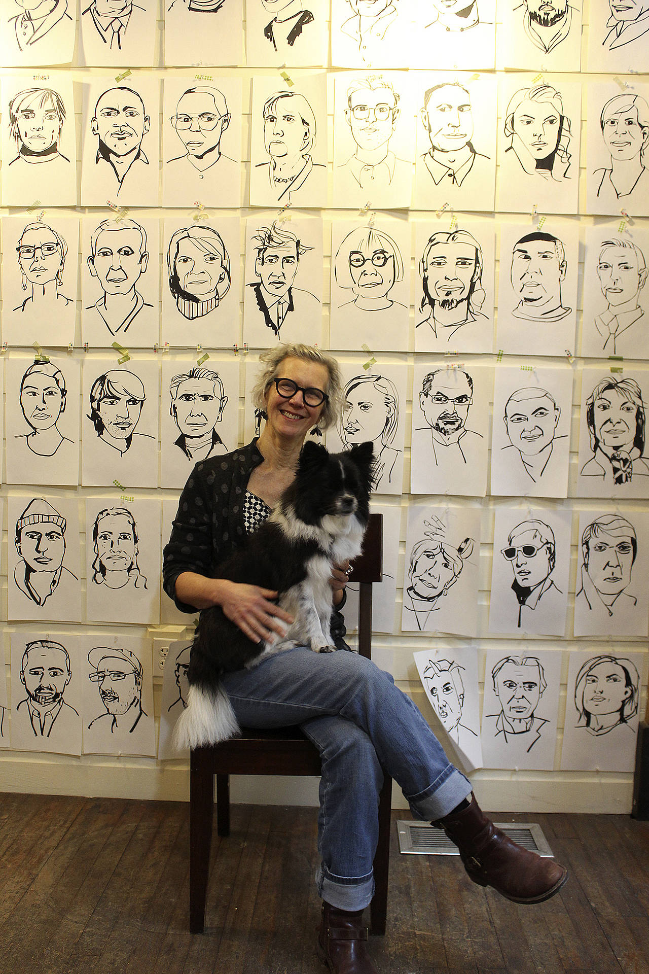 Meredith MacLeod poses with her dog, Mica, in front of some of her portraits. On Jan. 1, she’ll talk about the public response to the interactive art exhibit. Photo by Patricia Guthrie/Whidbey News Group)