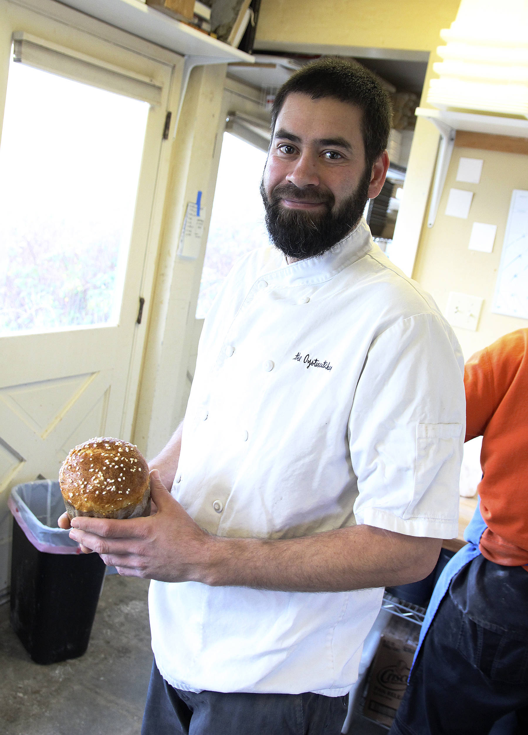 (Photo by Laura Guido/Whidbey News Times)                                Tyler Hansen, chef and owner of The Oystercatcher in Coupeville, holds a loaf of the restaurant’s holiday panettone. Left, herbs are applied liberally to make Roaming Radish executive chef/owner JP Dowell’s “perfect prime rib.”