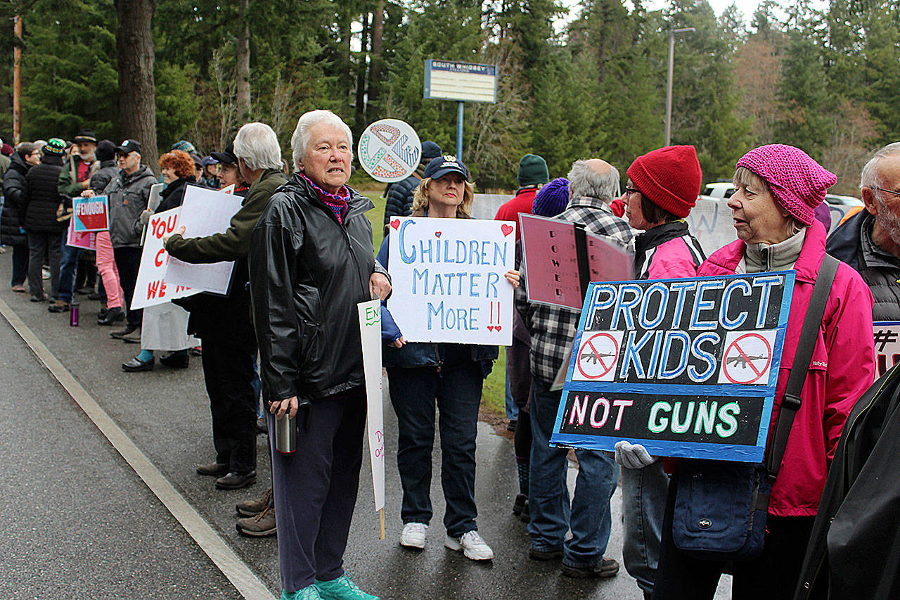 During National School Walkout Day March 14 parents and others joined students protesting with signs in front of South Whidbey High School. (Photo by Patricia Guthrie/ Whidbey News Group.)