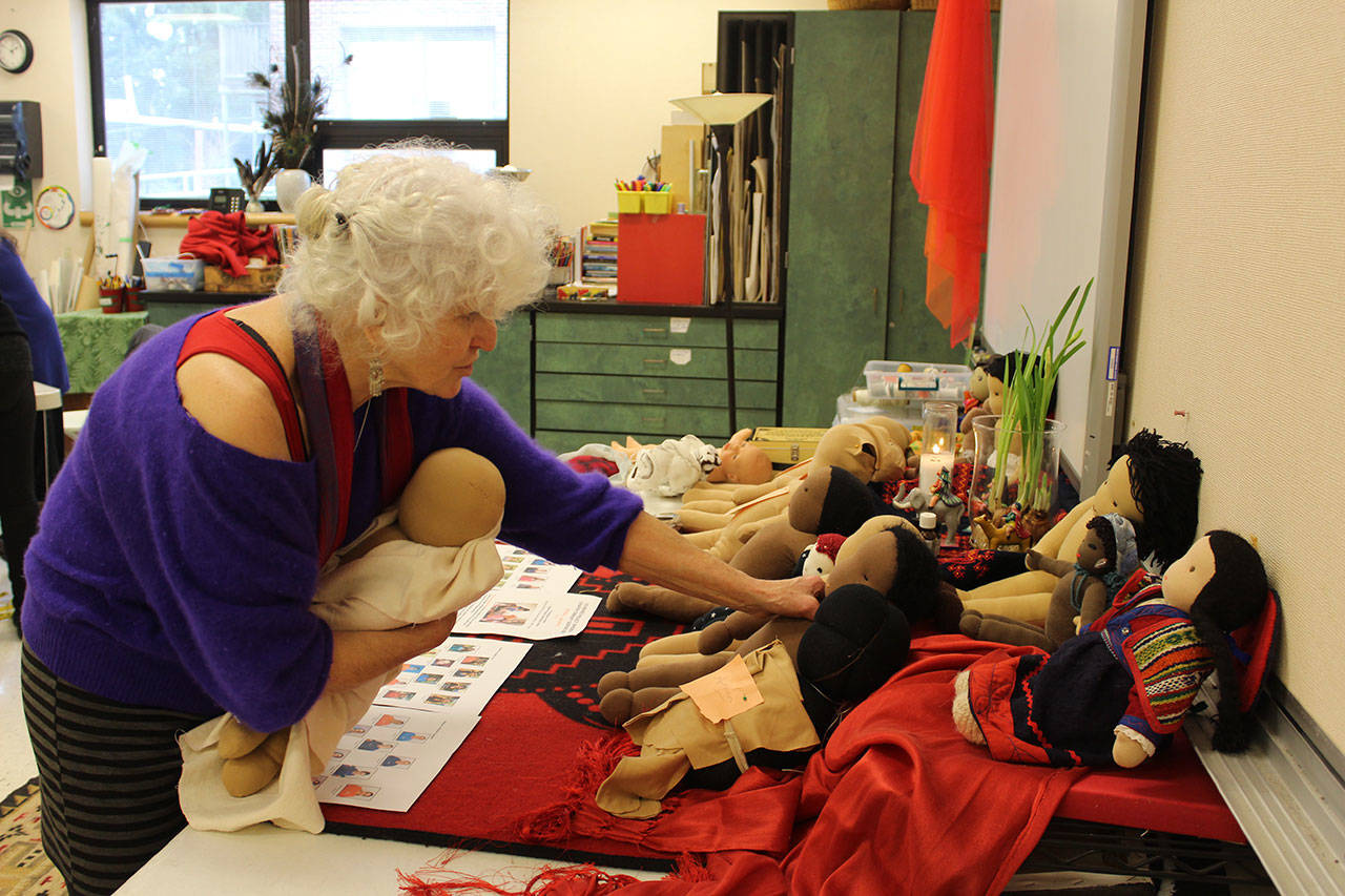 Gretchen Lawlor looks over small dolls being made by Whidbey Islanders for a maternal health project in rural Chiapas Mexico. (Photo by Patricia Guthrie/Whidbey News Group)