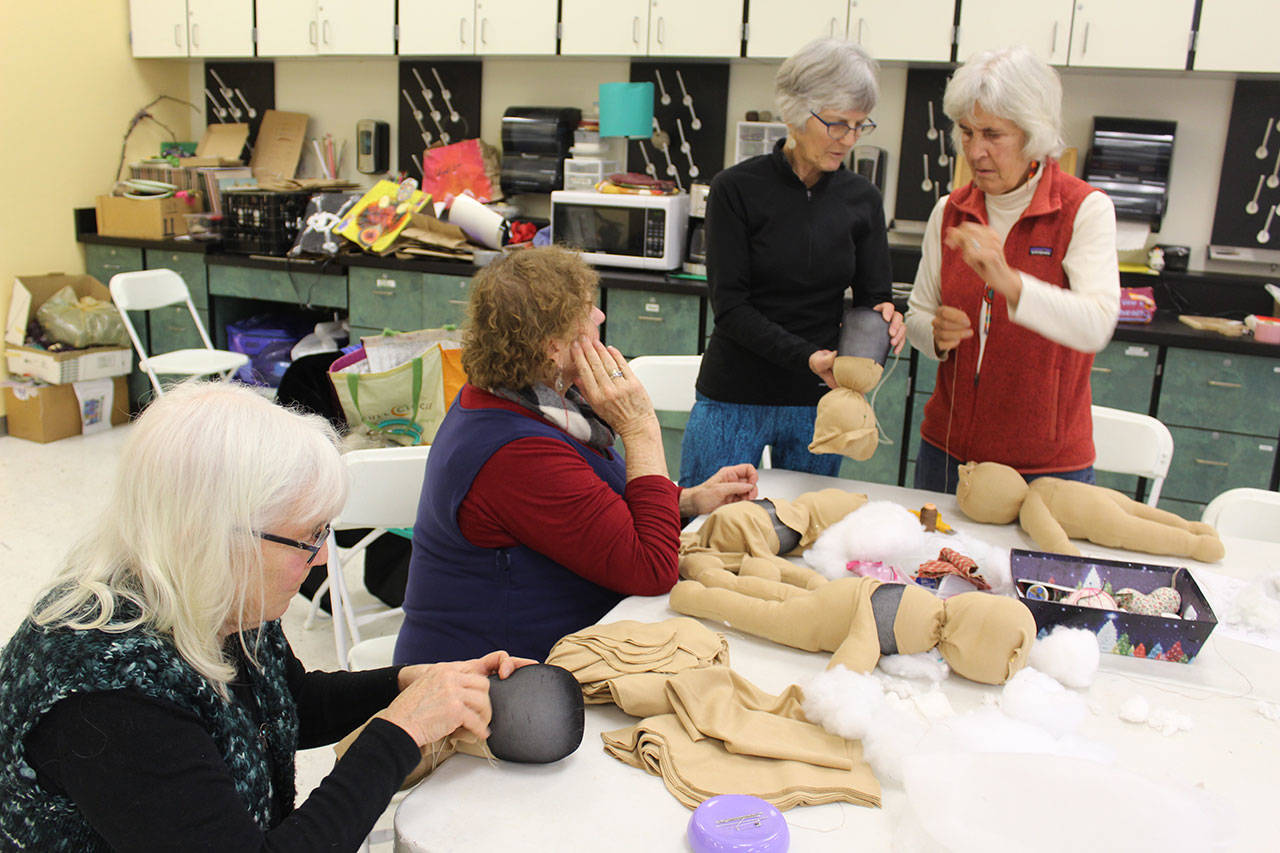 Volunteers with the Co-Madres Project who are making small cloth dolls to help mothers and families learn how to take care of newborns. The group meets on Friday afternoons at Langley’s Create Space at the South Whidbey Community Center. (Photo by Patricia Guthrie/Whidbey News Group)