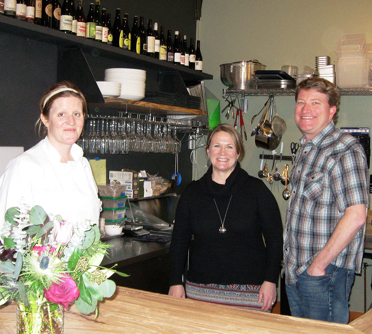Chef Maggie McGovern-Tu, left, prepares food at Farmer and the Vine wine bar in Bayview. Owners Jen and Josh Peters look on. (Photo by Dave Felice)