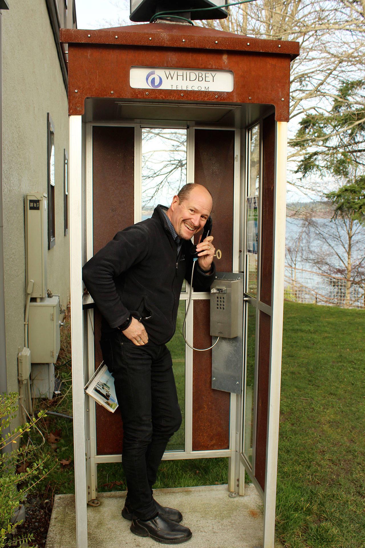 George Henny at one of 35 pay telephone booths Whidbey Telecom preserved and turned into a place to make free local calls. (Photo by Patricia Guthrie/Whidbey News Group)
