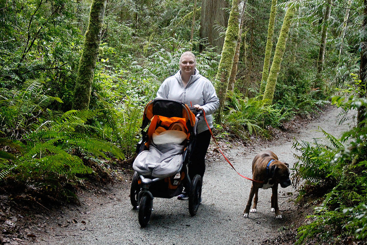 Elizabeth Nienhuis takes her daughter, Phoebe, and family dog, Rex, on a stroll down the Waterman Trail. Nienhuis says she regularly hikes the South Whidbey trail system in the mornings after dropping her older kids off at school. (Photo by Patricia Guthrie/Whidbey News Group)