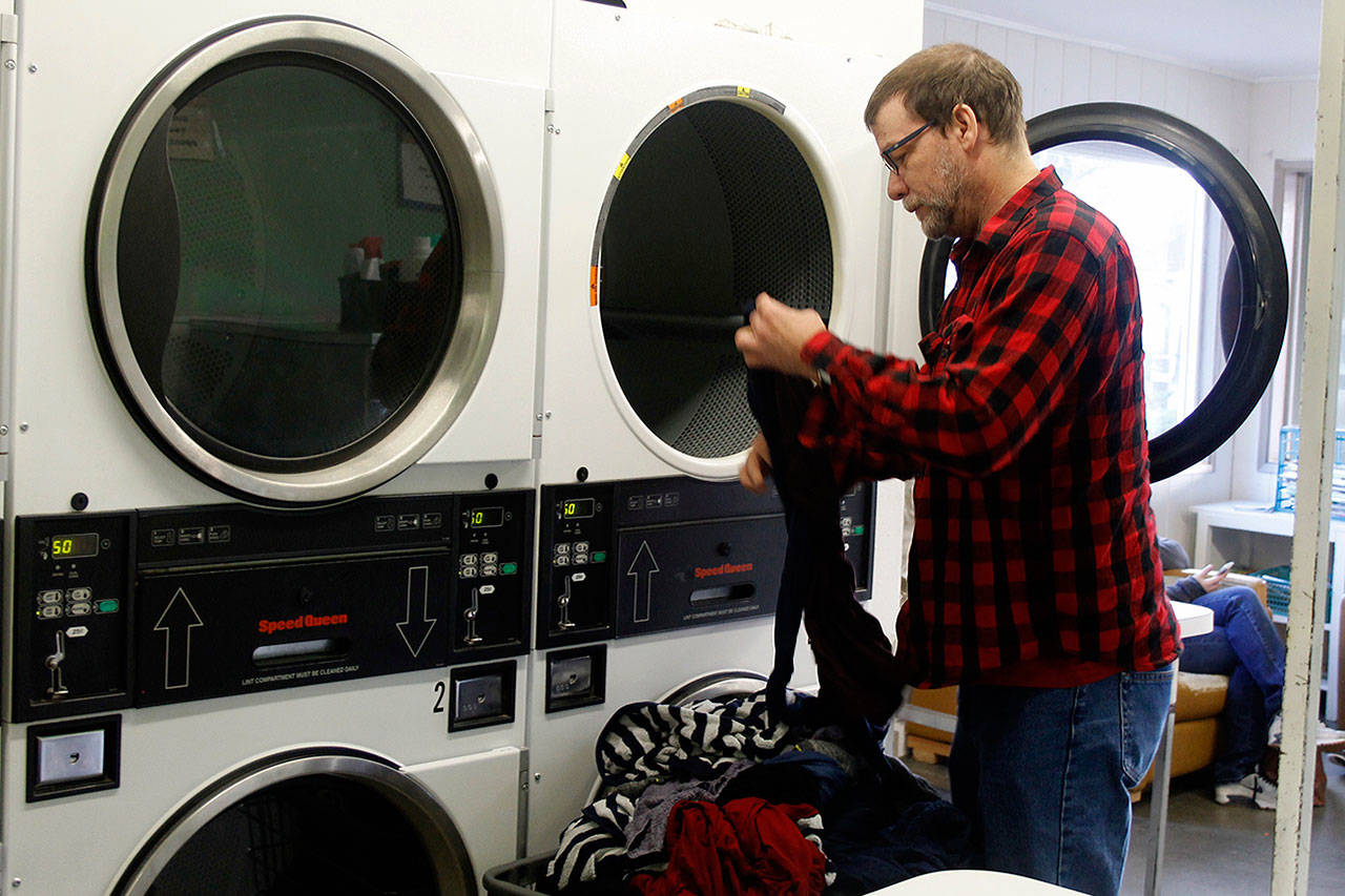 Ben Wooldridge makes more trips to do laundry than before the fire because he uses more towels for his burn recovery treatment. (Photo by Patricia Guthrie/Whidbey New Group)