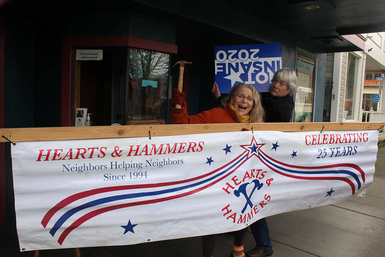 Partners in life and creativity, David Ossman and Judith Walcutt pose in front of Langley’s Clyde Theatre with props for a March 16 benefit performance for South Whidbey Hearts & Hammers. (Photo by Patricia Guthrie/Whidbey News Group)