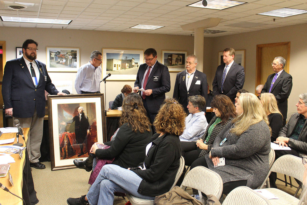 Members of the Langley Masonic Lodge present a portrait of President George Washington to Langley Mayor Tim Callison and the city council. (Photo by Patricia Guthrie/Whidbey News Group)