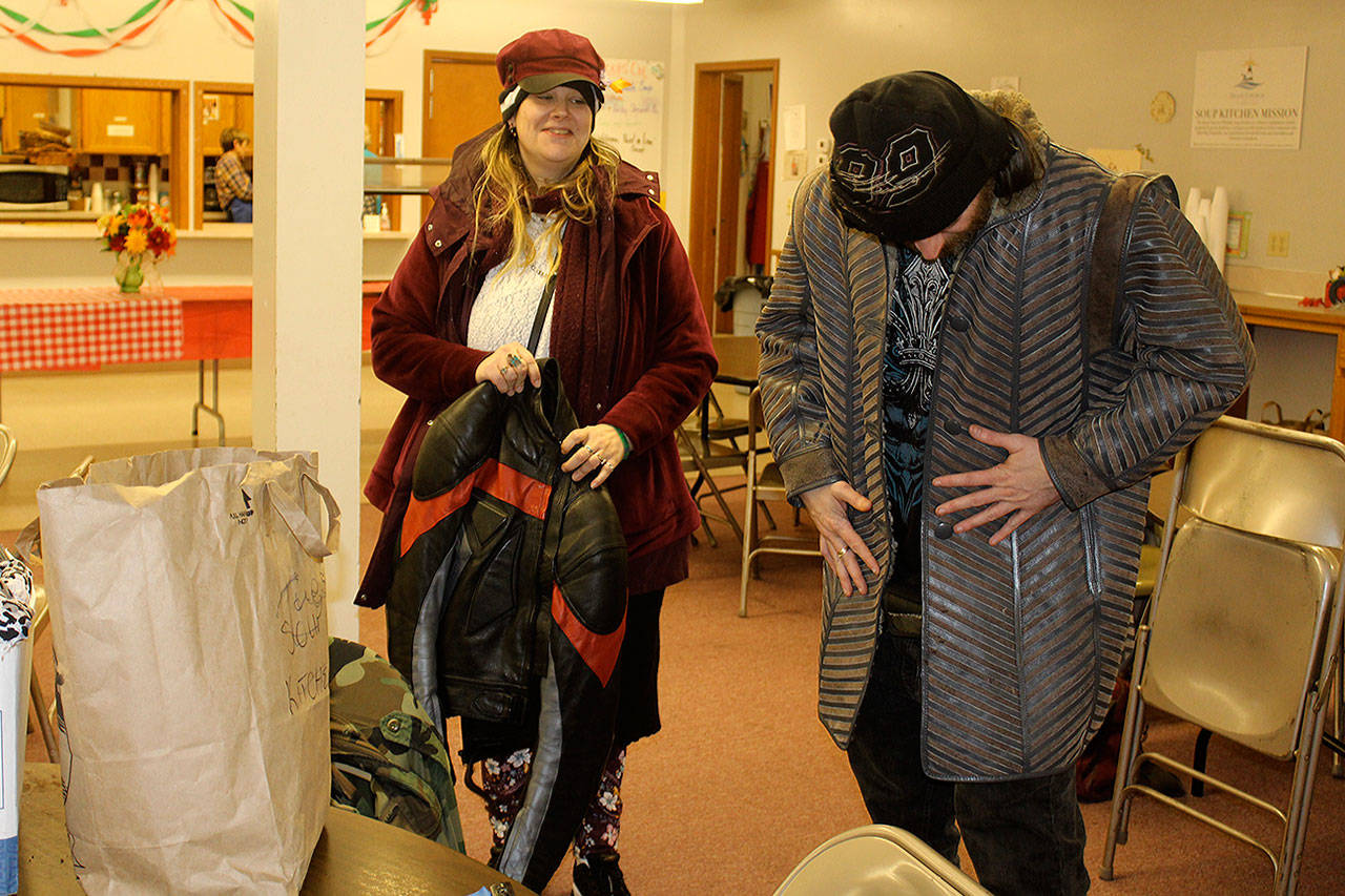 Margo and Darrin Hutchinson Jr. try on donated coats after having a meal Thursday at Island Church of Whidbey in Langley. The church was the hub for South Whidbey Point in Time count activities. (Photo by Patricia Guthrie/Whidbey News Group)
