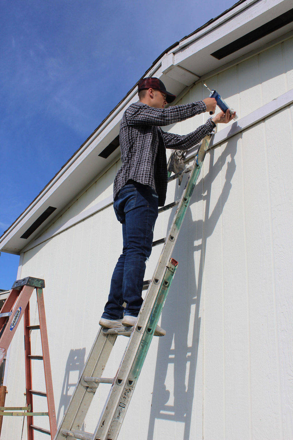 Photo by Patricia Guthrie/South Whidbey Record.                                Cameron Toomey-Stout helped weatherproof a house during last year’s Central Whidbey Hearts Hammers Work Day.