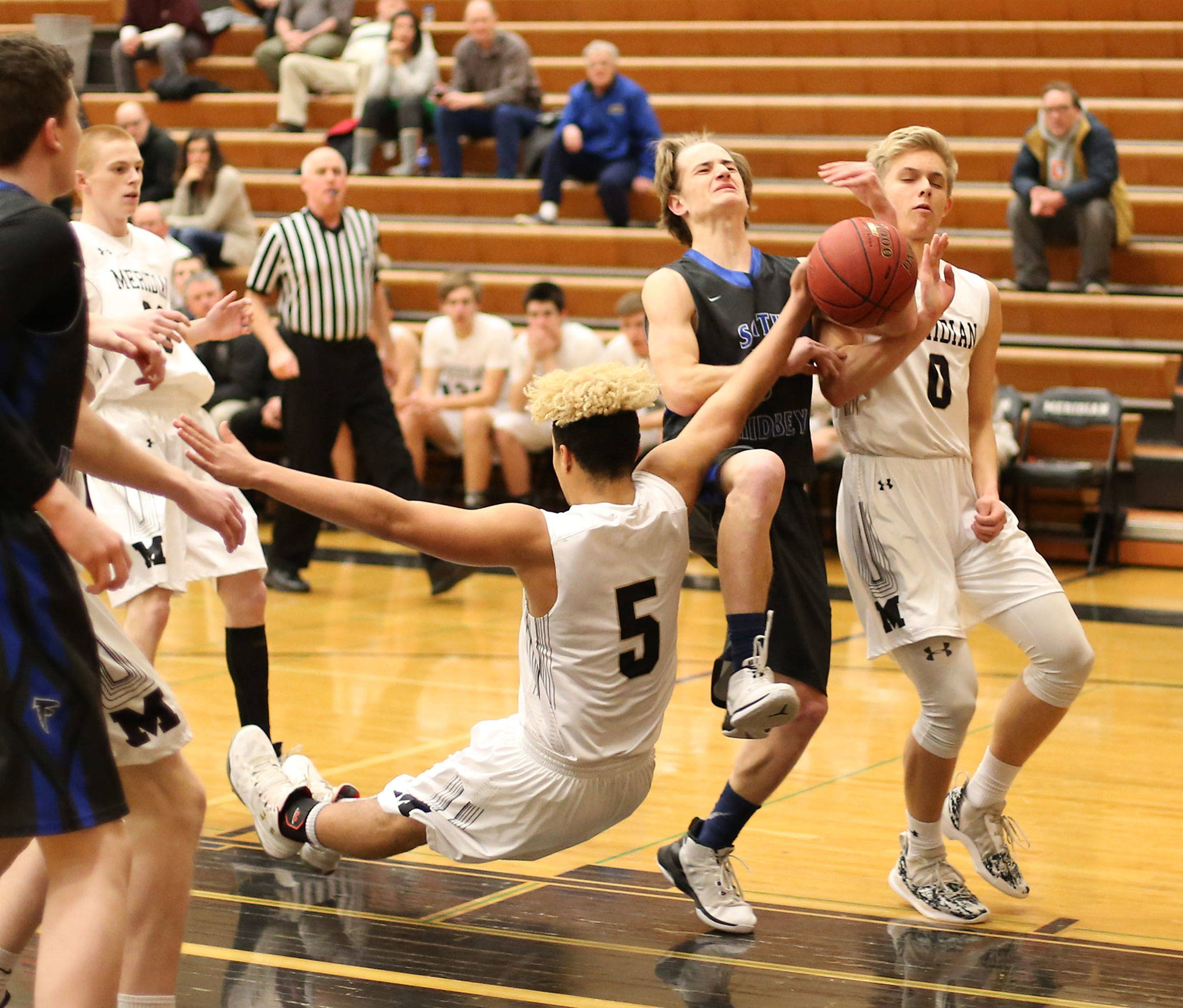 Kody Newman is fouled by Meridian’s Cameron Webster (5) on the way to the hoop.(Photo by John Fisken)