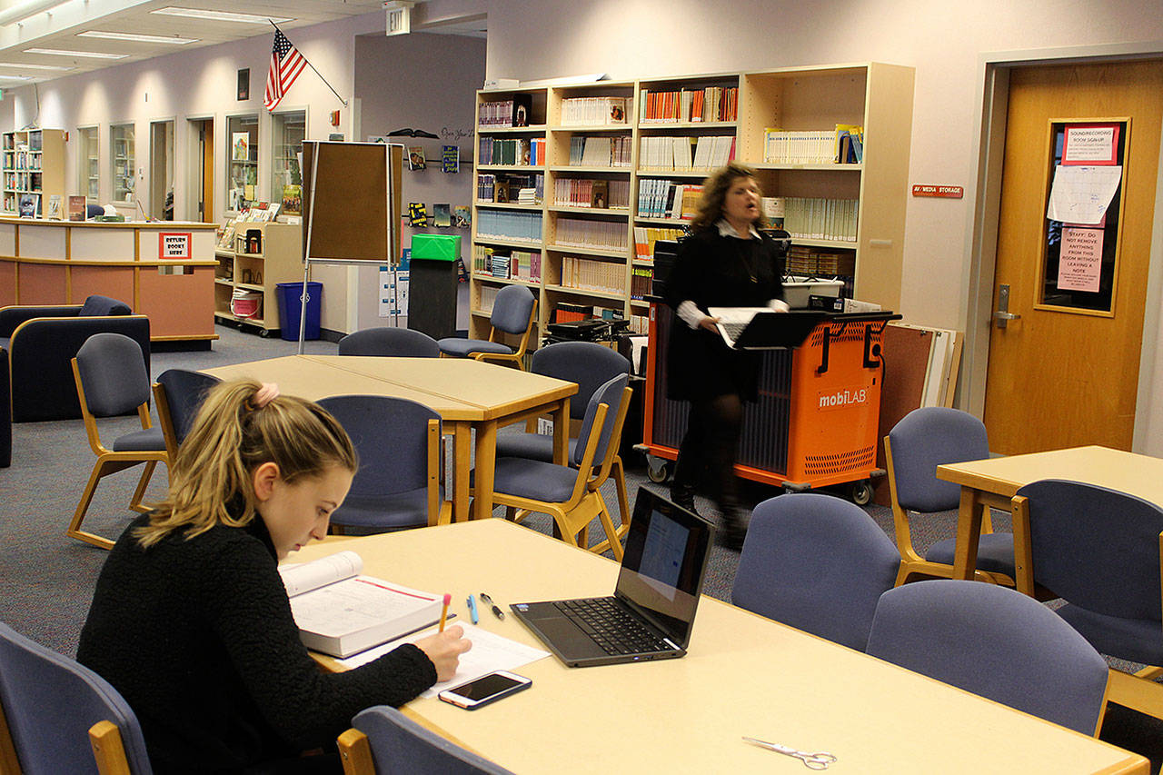 Senior Erin Brewer studied in the South Whidbey High School library using both a calculus text book and one of the 1,300 Chromebook computers bought with previous levy funding approved by voters. (Photo by Patricia Guthrie/Whidbey News Group)