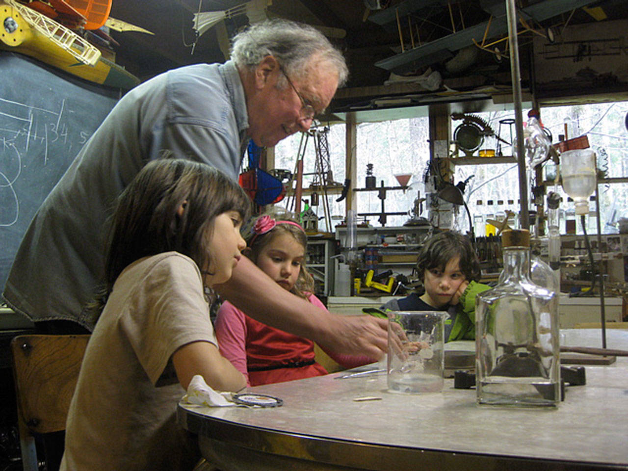 In this 2014 photo, teacher Leonard Good leads young students through an experiment in his science classroom located behind his Langley home. Laboratory equipment, model airplanes and educational material were lost to a fire Wednesday that heavily damaged the structure’s roof and storage attic. (Photo provided)