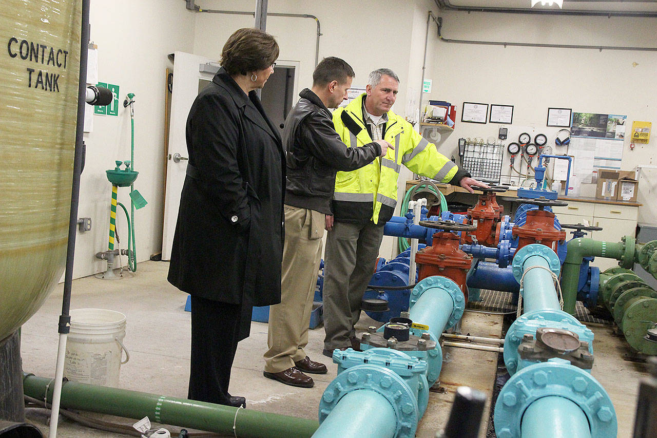 Coupeville Mayor Molly Hughes, Naval Air Station Whidbey Island commander Capt. Matt Arny, and town Utility Superintendent Joe Grogan discuss how a new water filtration system will work with the existing process. Photo by Laura Guido/Whidbey News-Times